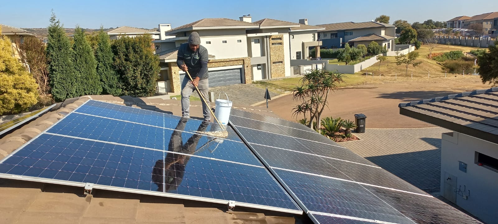 DSD technician cleaning and maintaining rooftop solar panels in Pretoria